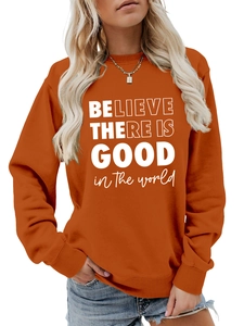 Dettaglio della felpa arancione girocollo con stampa bianca Believe There Is Good