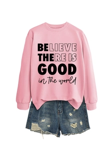 Dettaglio felpa rosa con scritta 'Believe there is good' e pantaloncini di jeans strappati