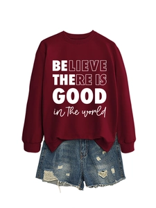 Dettaglio della felpa bordeaux con scritta bianca e pantaloncini in denim strappati