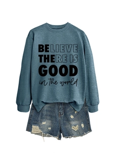 Dettaglio della felpa blu con stampa grafica e pantaloncini di jeans con strappi moda