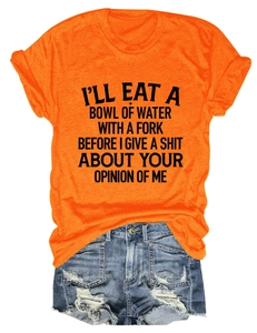 Flat lay of orange slogan t-shirt paired with ripped denim shorts on white background