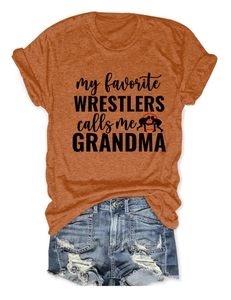 Détail du t-shirt orange avec silhouette de lutteurs et slogan rétro sur short en jean