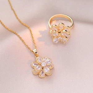 Vue détaillée d'une parure de bijoux fleur dorée avec zircons sur tissu en soie