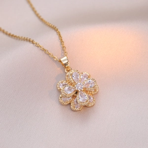 Macro d'un pendentif fleur rotatif en or avec zircons sur un tissu en soie douce