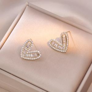 Elegant gold heart stud earrings with sparkling baguette diamonds and crystal halo