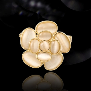 Élégante broche camélia avec pierres d'opale crème et contours en métal doré