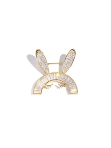 Détail macro d'une broche lapin mignonne en métal doré et pierres zircon