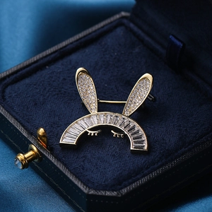 Broche lapin mignonne avec zircons et finition dorée sur boîte à bijoux en velours