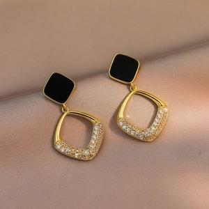 Eleganti orecchini geometrici a pendente con perno nero e pavé di diamanti brillanti