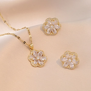 Detailed view of gold flower jewelry set with zircon petals on silk background