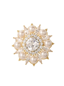 Gros plan détaillé d'une broche ronde vintage avec perles blanches et pierre carrée
