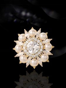 Détail d'une broche ronde vintage avec perles et zircon de coupe carrée sur fond noir