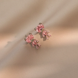 Elegante silberne Bären-Ohrstecker mit rosa Zirkonia auf champagnerfarbenem Satin