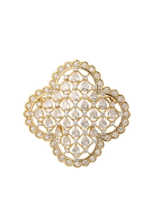 Détail d'une broche trèfle dorée ornée de zircons et de finitions en maille métallique