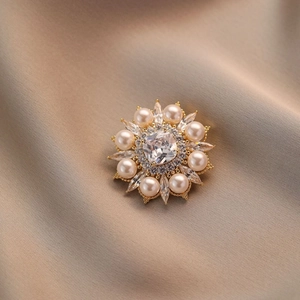 Broche soleil dorée élégante avec grand zircon central et accents de perles