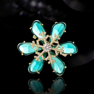 Exquisite golden snowflake brooch featuring blue teardrop crystals and micro-pave accents