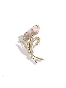 Dettaglio macro di spilla a tulipano con petali in opale rosa e steli d'oro e zirconi