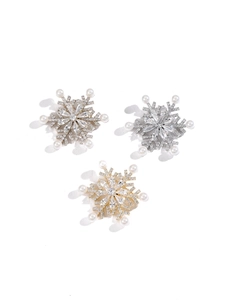 Macro detail of snowflake brooches with cubic zirconia and pearls in gold and silver