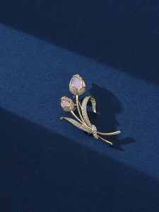 Dettaglio della spilla a tulipano con gemme rosa e cristalli lucidi su metallo dorato