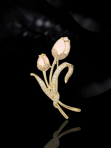 Dettaglio di un'elegante spilla a tulipano dorata con petali rosa e cristalli