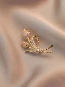 Dettaglio spilla a tulipano con petali di opale rosa e cristalli su tessuto di seta