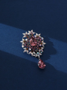 Detail of vintage flower brooch with pear-shaped purple crystals and silver setting