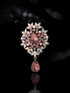 Macro view of vintage silver brooch featuring pink waterdrop stones and colorful crystals
