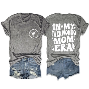 Flat lay of gray Taekwondo Mom Era cotton t-shirt with front and back graphic prints