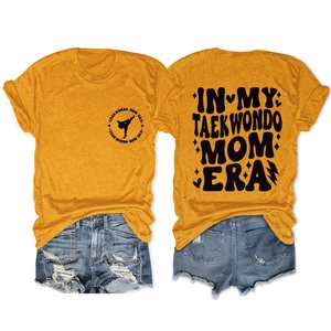 Flat lay of ginger crew neck t-shirt with Taekwondo Mom Era print and denim shorts