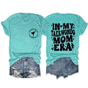 Flat lay view of mint green taekwondo t-shirt showing front logo and back typography