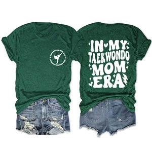 Detailed flat lay of dark green Taekwondo Mom Era T-shirt and distressed denim shorts