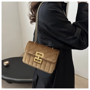Dettaglio ravvicinato di una borsa a tracolla vintage in velluto marrone con catena
