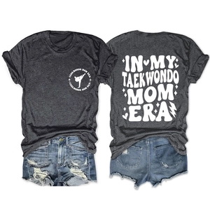 Flat lay of gray T-shirt with Taekwondo Mom Era graphic and denim shorts set