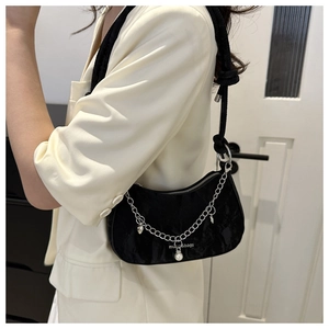 Détail du sac à bandoulière plissé noir avec chaîne argentée et breloque perle