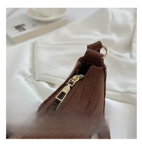 Détail du zip en métal doré lisse sur un sac à bandoulière matelassé marron foncé
