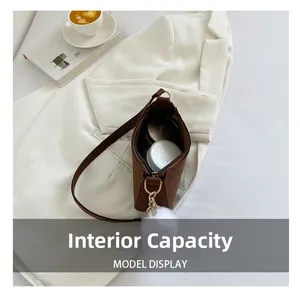 Vue intérieure d'un sac à bandoulière marron effet crocodile avec charme blanc doux
