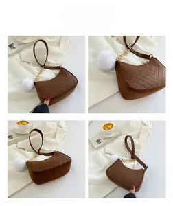 Détails du sac hobo matelassé marron avec chaîne dorée et breloque pompon blanc élégante