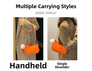 Détail du sac bandoulière matelassé orange avec chaîne dorée et pompon blanc