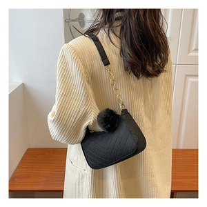 Sac à épaule chic en feutre noir matelassé avec chaîne dorée et pompon en peluche