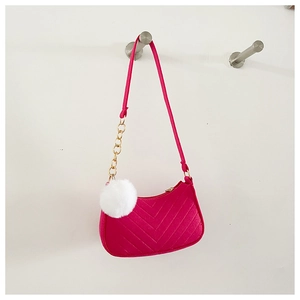 Détail du sac à épaule en feutre rose avec matelassage en V et pompon blanc duveteux