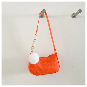 Détail du sac sous le bras en feutre orange surpiqué avec chaîne et pompon blanc doux