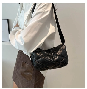 Détail du sac bandoulière matelassé noir avec coutures en losange et large bandoulière