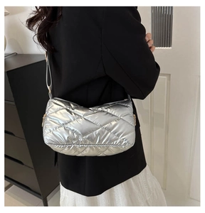 Détail du sac à bandoulière matelassé argenté avec finition métallisée chic