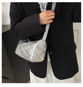 Détail du sac matelassé argenté avec finition métallique et bandoulière en tissu