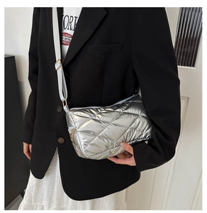 Détail du sac matelassé argenté avec bandoulière réglable et ferrures dorées