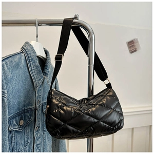 Détail du sac matelassé noir en nylon brillant avec bandoulière et boucle en métal ajustable