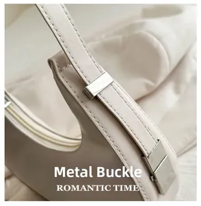 Close-up of silver metal clasp on minimalist beige leather shoulder bag detail