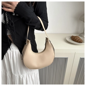 Detail of minimalist beige moon hobo bag showing smooth PU leather and metal buckle hardware