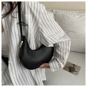 Close-up of black leather hobo bag with adjustable strap and silver metal hardware