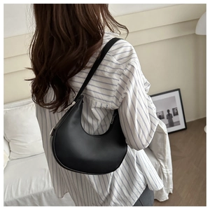 Detail of minimalist black crescent hobo bag made of matte leather with silver hardware